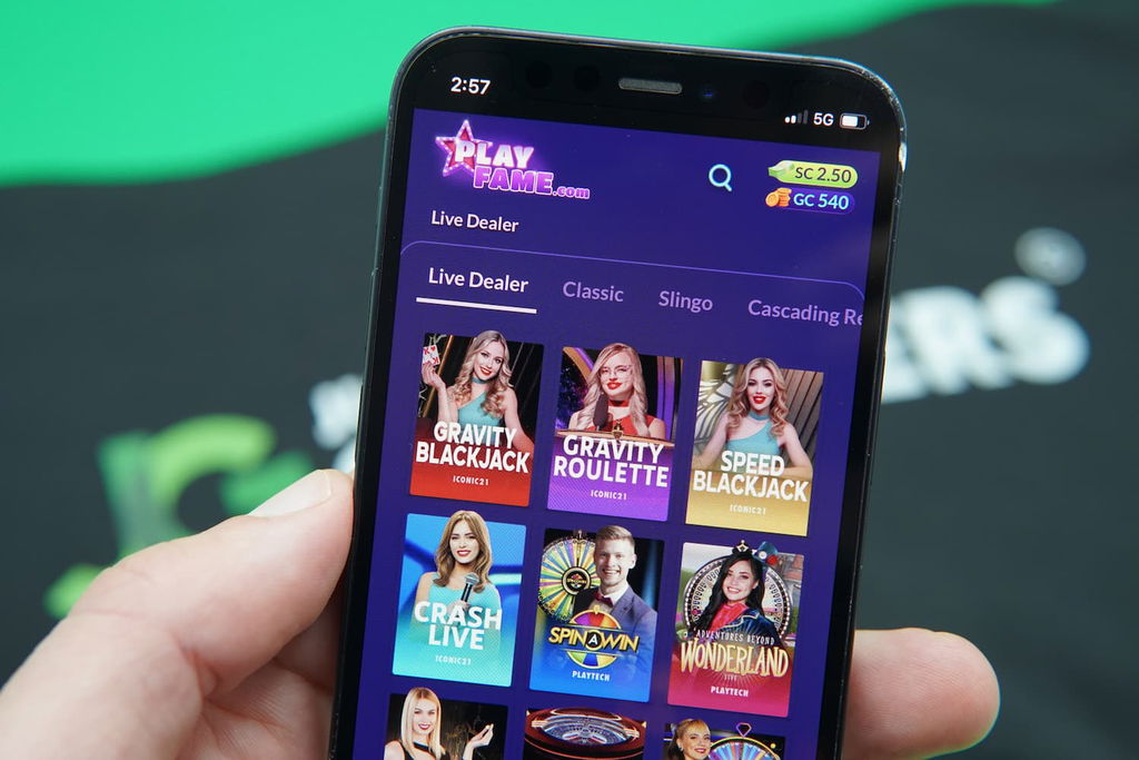 Patrik Lidin holding an iPhone with the PlayFame game library page loaded on the webpage.