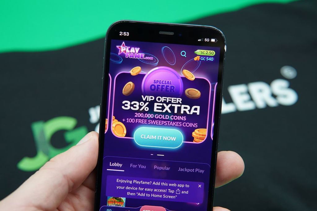 Patrik Lidin holding an iPhone with the PlayFame lobby page loaded on the webpage.