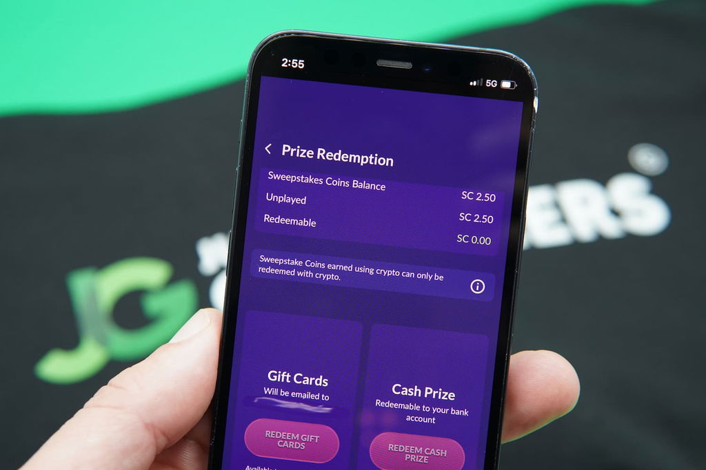 Patrik Lidin holding an iPhone wit h the PlayFame redemptions page loaded on the webpage.