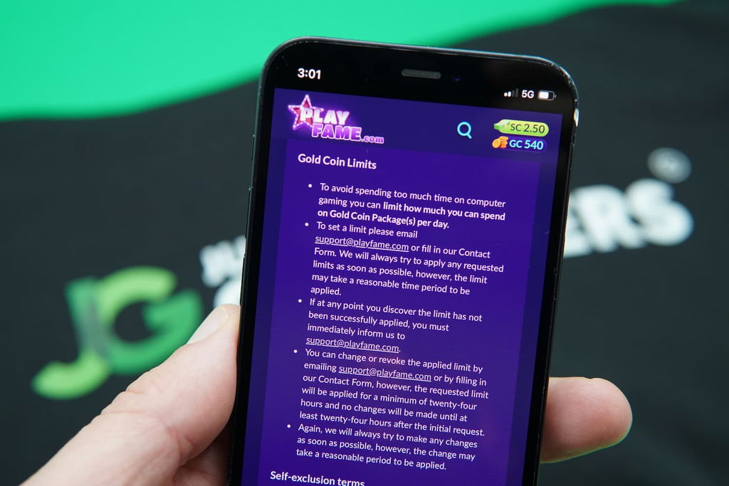 Patrik Lidin holding an iPhone with the PlayFame responsible gambling page loaded on the webpage.