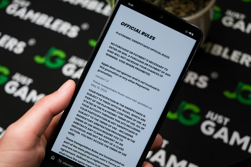 Angela Zillich holding an Android Phone with Playnomic casino AMOE page loaded on the webpage.