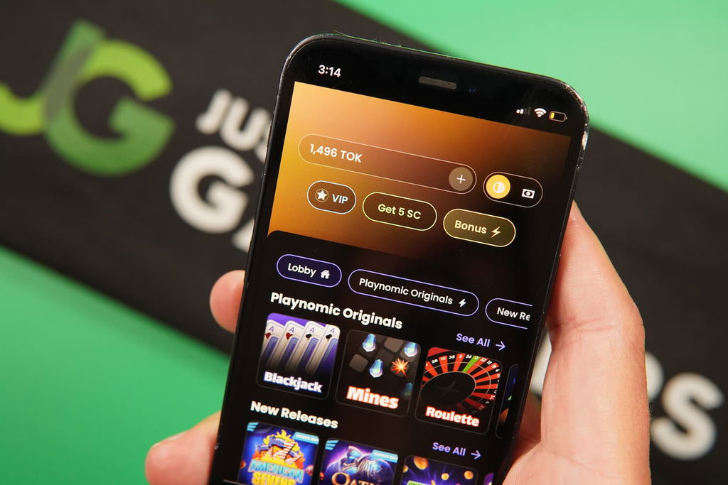 Patrik Lidin holding an iPhone with the Playnomic casino landing page loaded on the webpage.