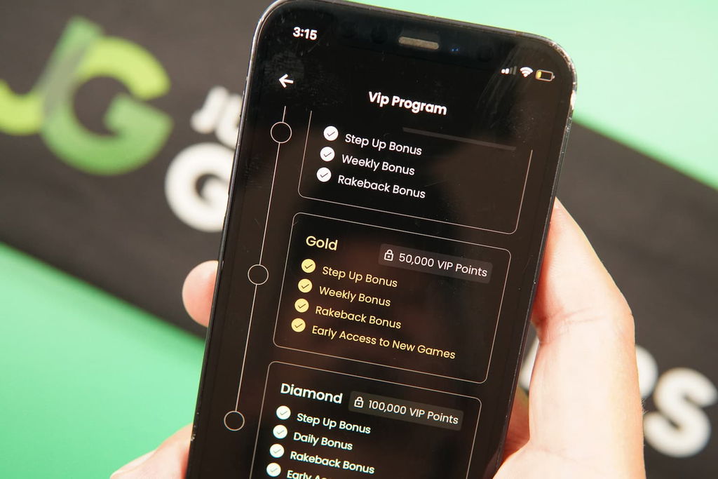 Patrik Lidin holding an iPhone with the Playnomic casino Loyalty Program page loaded on the webpage.
