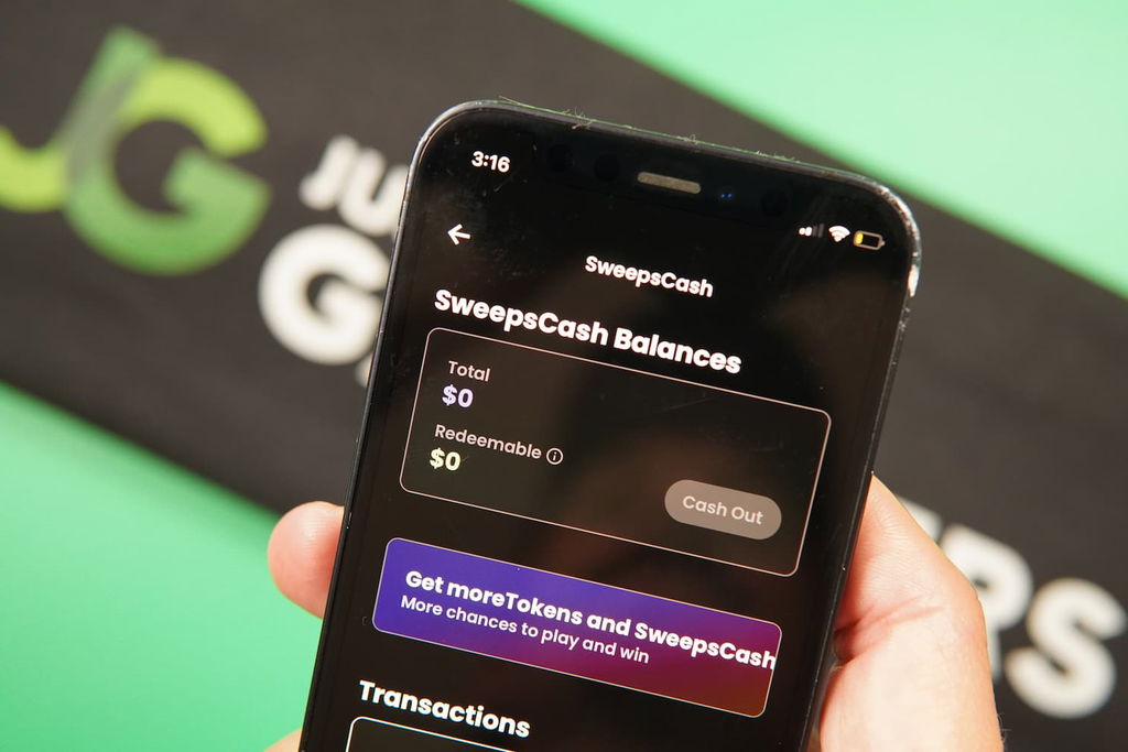 Patrik Lidin holding an iPhone with the Playnomic casino redemptions page loaded on the webpage.