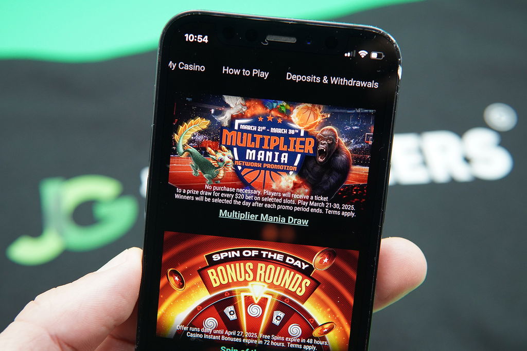 Photo of Patrik Lidin holding iPhone with PokerStars NJ welcome bonus loaded.