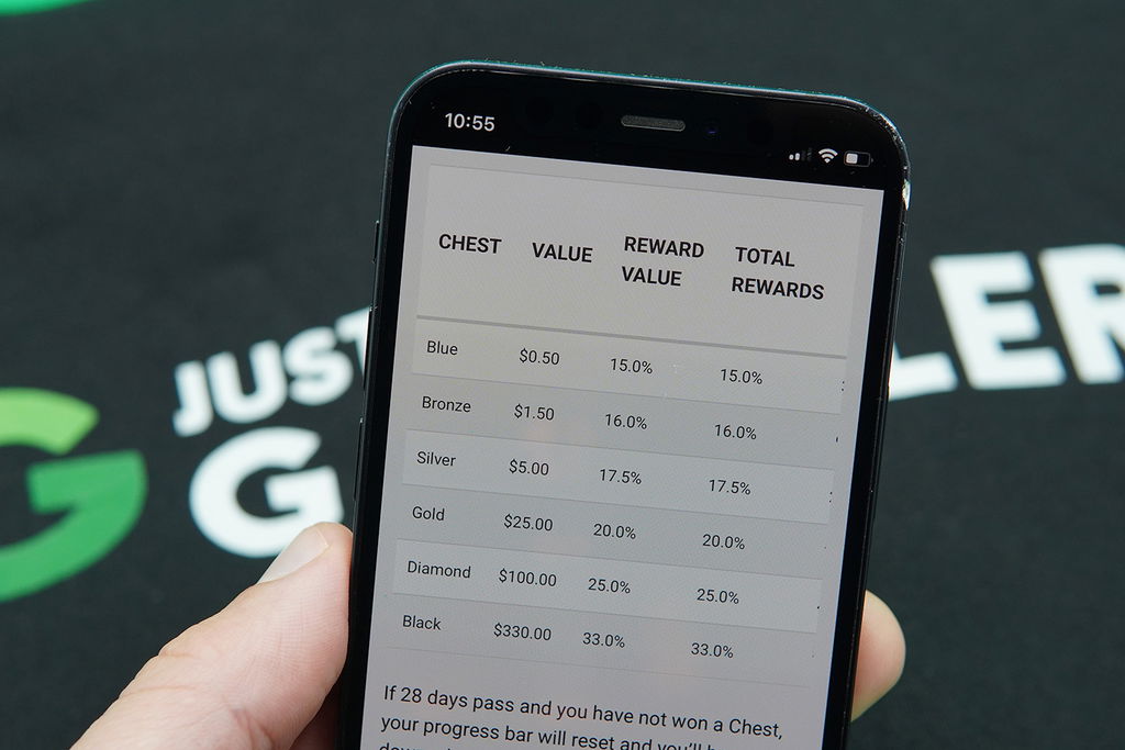 Photo of Patrik Lidin holding an iPhone with the PokerStars loyalty program loaded.