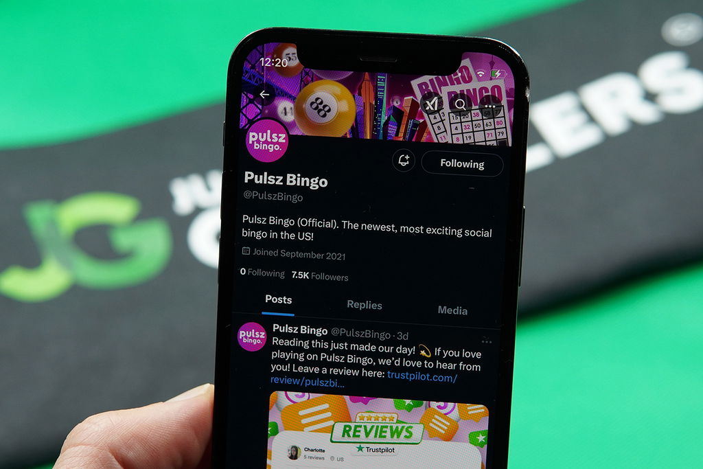 Patrik Lidin holding an iPhone with the Pulsz Bingo X account.