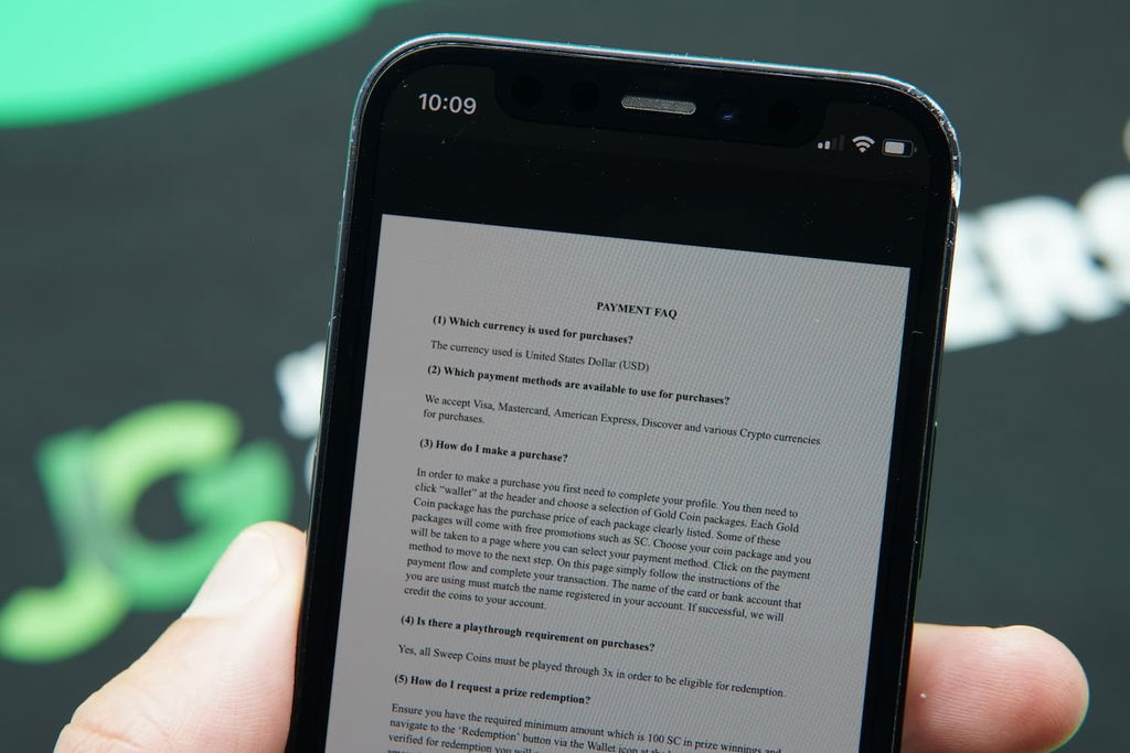 Patrik Lidin holding an iPhone with the Punt casino Support FAQ page loaded on the webpage.