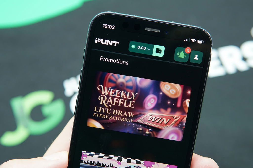 Patrik Lidin holding an iPhone with the Punt casino promotions page loaded on the webpage.