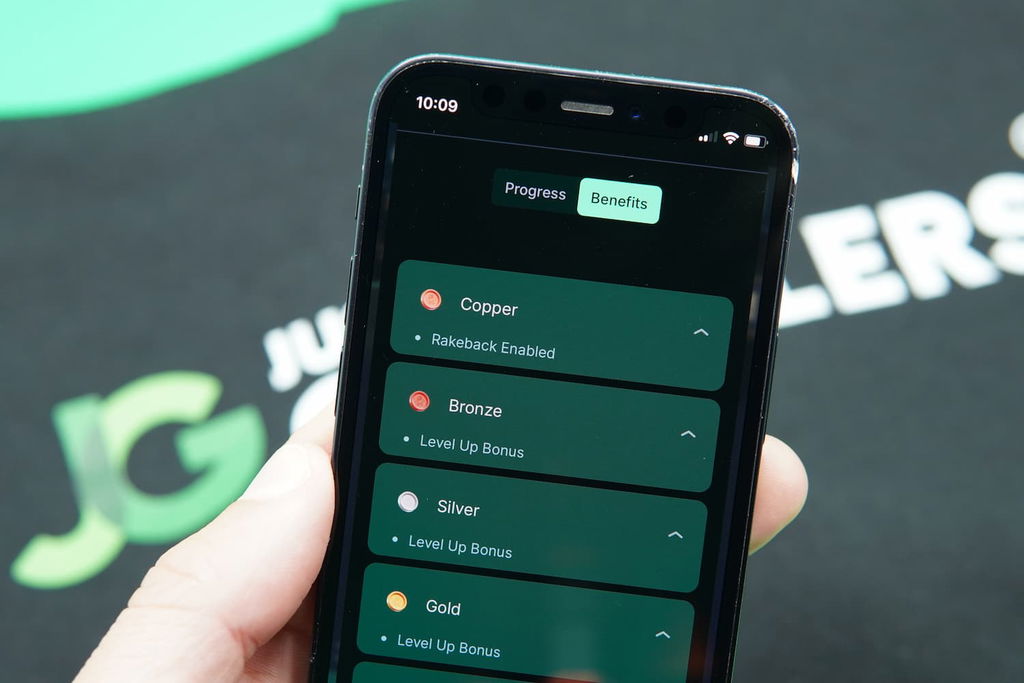 Patrik Lidin holding an iPhone with the Punt casino VIP page loaded on the webpage.