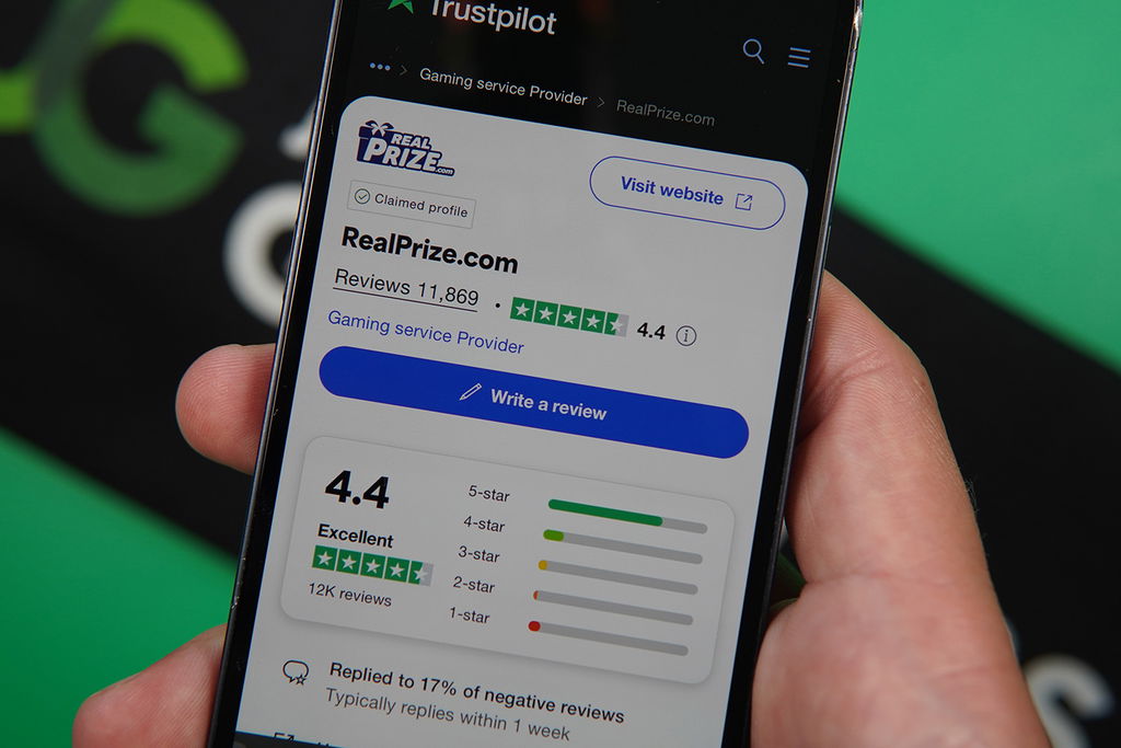 Photo of Patrik Lidin holding iPhone with RealPrize TrustPilot showing.