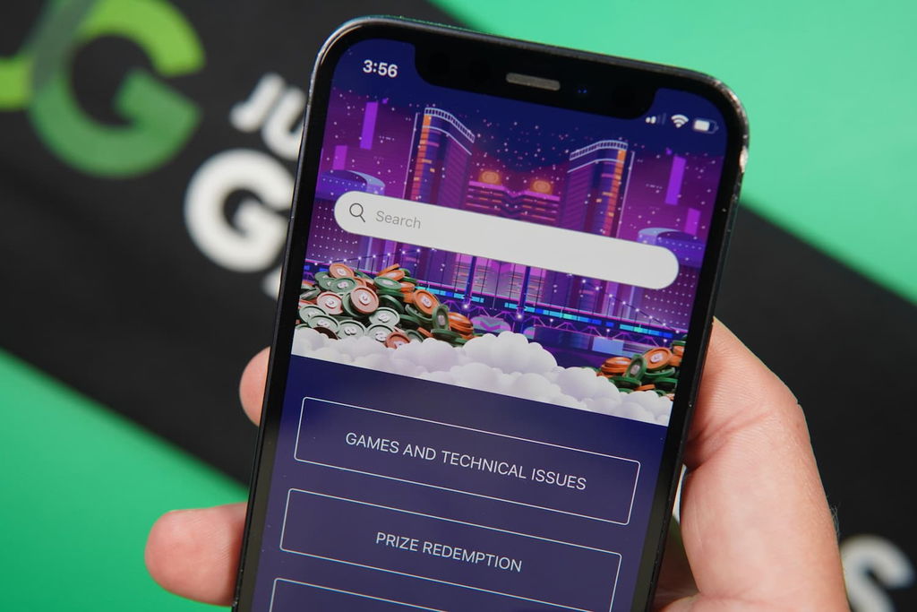Patrik Lidin holding an iPhone with the RealPrize casino customer support page loaded on the webpage.