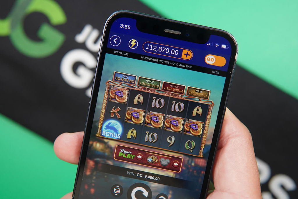 Patrik Lidin holding an iPhone with the RealPrize casino in-game mobile page loaded on the webpage.