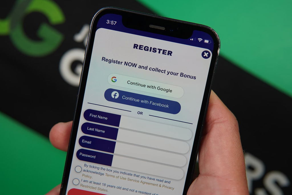 Patrik Lidin holding an iPhone with the RealPrize casino registration page loaded on the webpage.