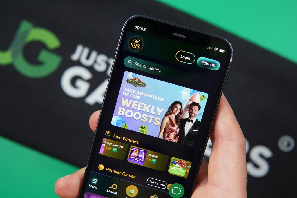 Patrik Lidin holding an iPhone with the RichSweeps casino landing page loaded on the webpage.