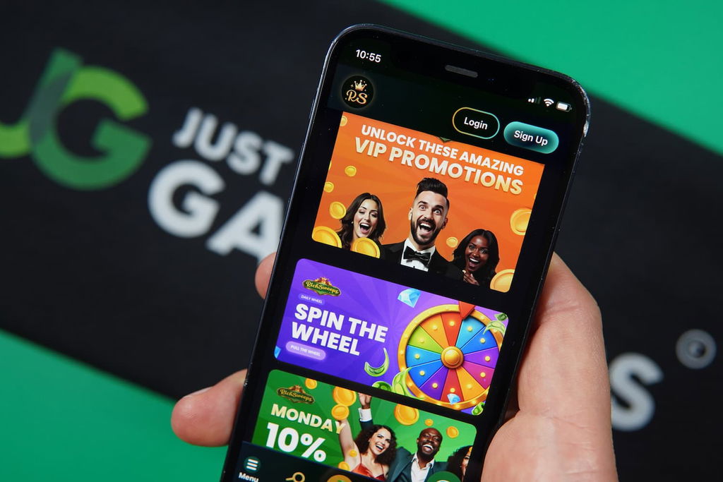 Patrik Lidin holding an iPhone with the RichSweeps casino promotions page loaded on the webpage.