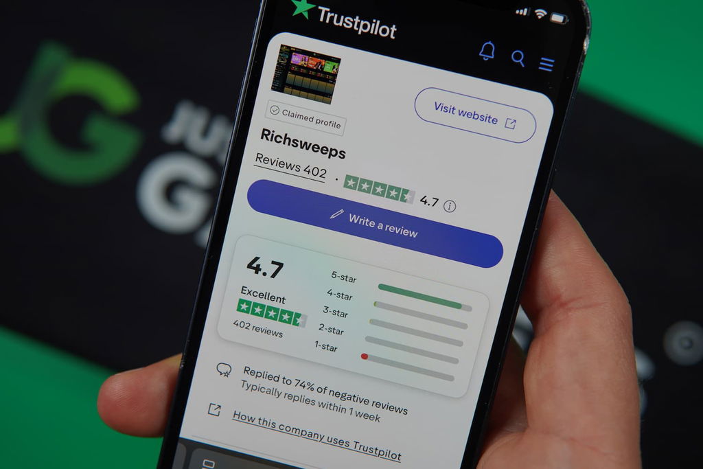 Patrik Lidin holding an iPhone with the RichSweeps casino Trustpilot page loaded on the webpage.