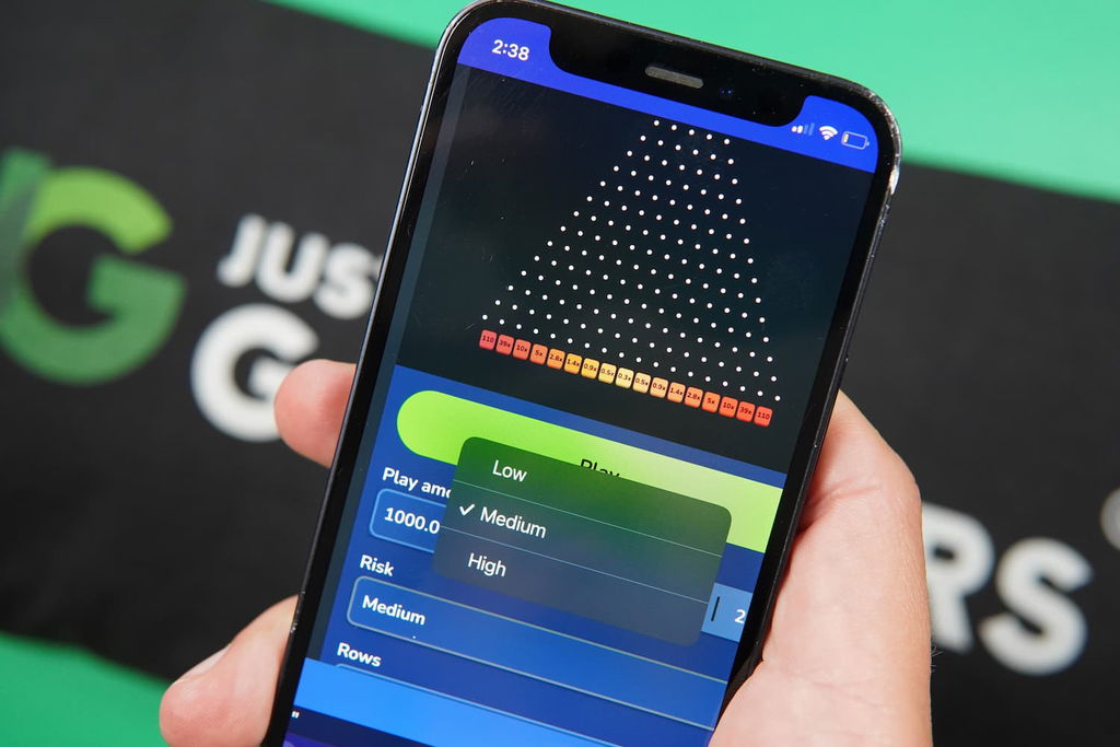 Photo of Patrik Lidin holding an iPhone showing the risk-level option in Plinko.