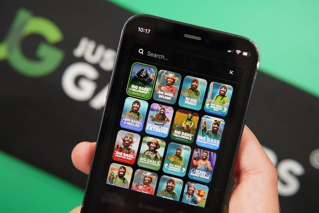 Patrik Lidin holding an iPhone with the Rolla casino game library page loaded on the webpage.