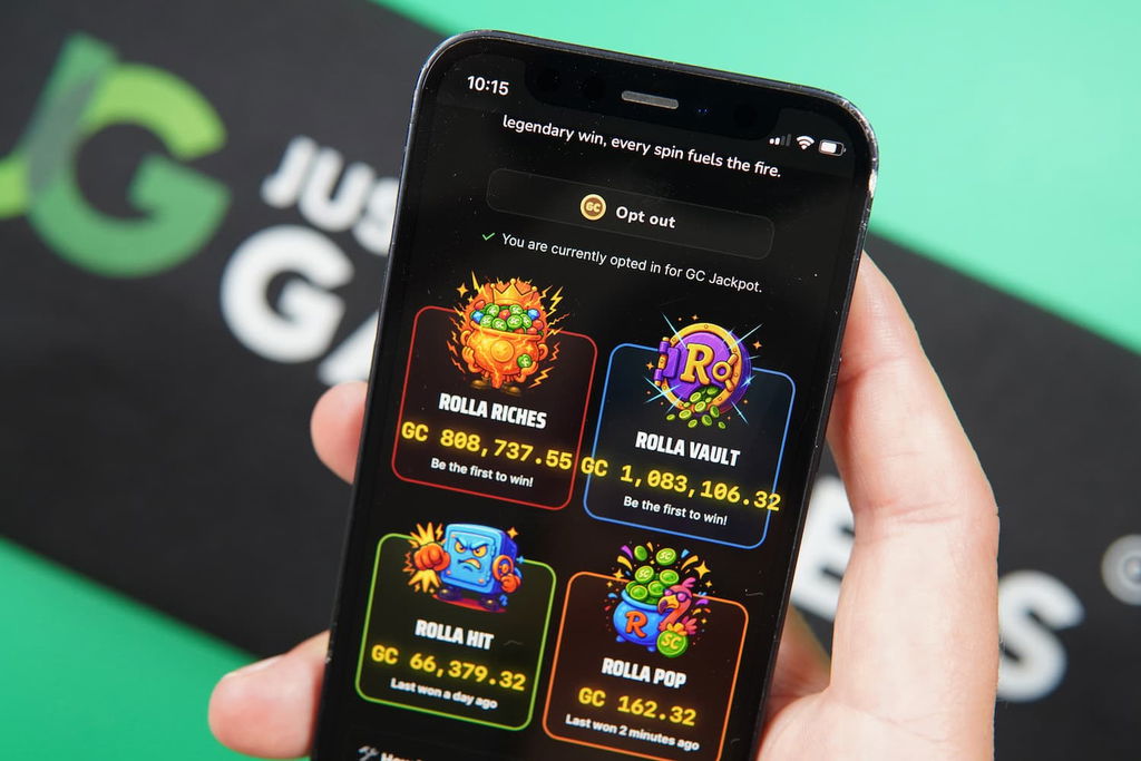 Patrik Lidin holding an iPhone with the Rolla casino jackpots page loaded on the webpage.