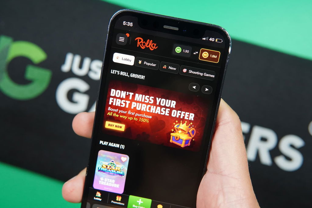 Patrik Lidin holding an iPhone with the Rolla casino landing page loaded on the webpage.