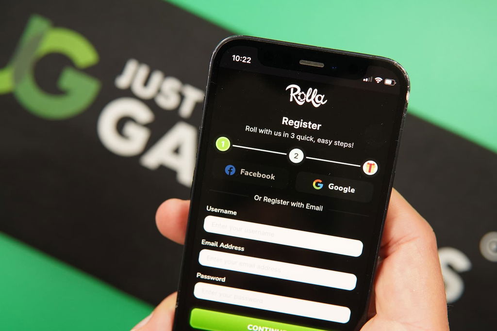 Patrik Lidin holding an iPhone with the Rolla casino registration page loaded on the webpage.