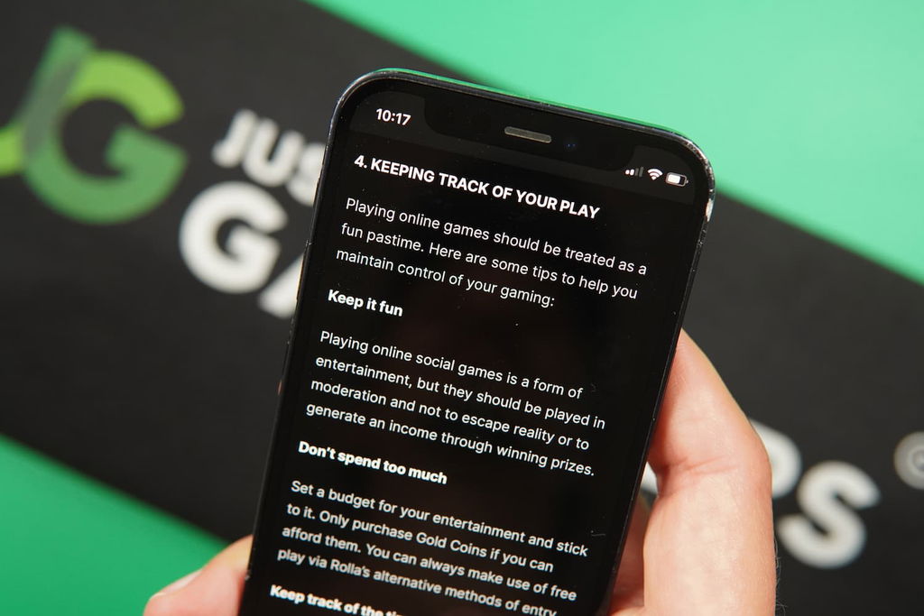 Patrik Lidin holding an iPhone with the Rolla casino responsible gaming page loaded on the webpage.