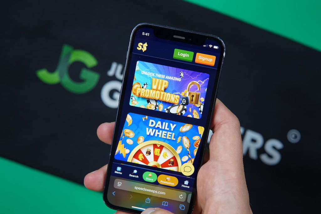 Patrik Lidin holding an iPhone with the SpeedSweeps casino promotions page loaded on the webpage.