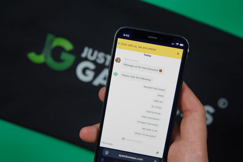 Patrik Lidin holding an iPhone with the SpeedSweeps casino support page loaded on the webpage.