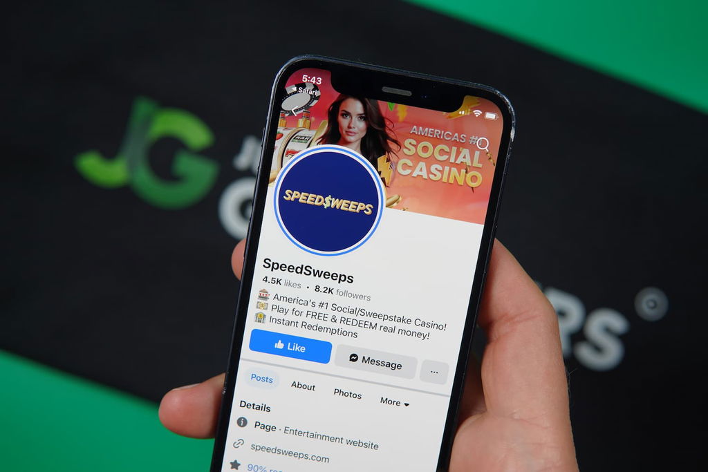 Patrik Lidin holding an iPhone with the SpeedSweeps casino trust fb social media page loaded on the webpage.