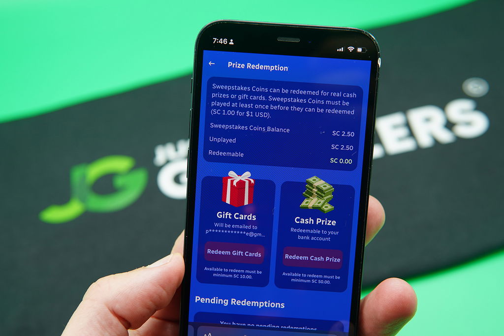 Patrik Lidin holding an iPhone with the SpinBlitz redemptions loaded on the webpage.