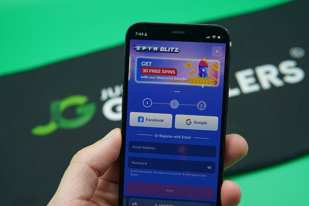 Patrik Lidin holding an iPhone showing the SpinBlitz registration process.