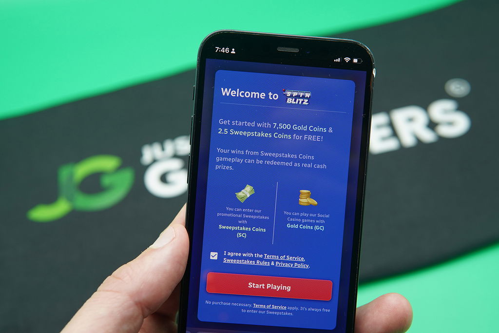 Patrik Lidin holding an iPhone showing the SpinBlitz registration reward loaded on the webpage.