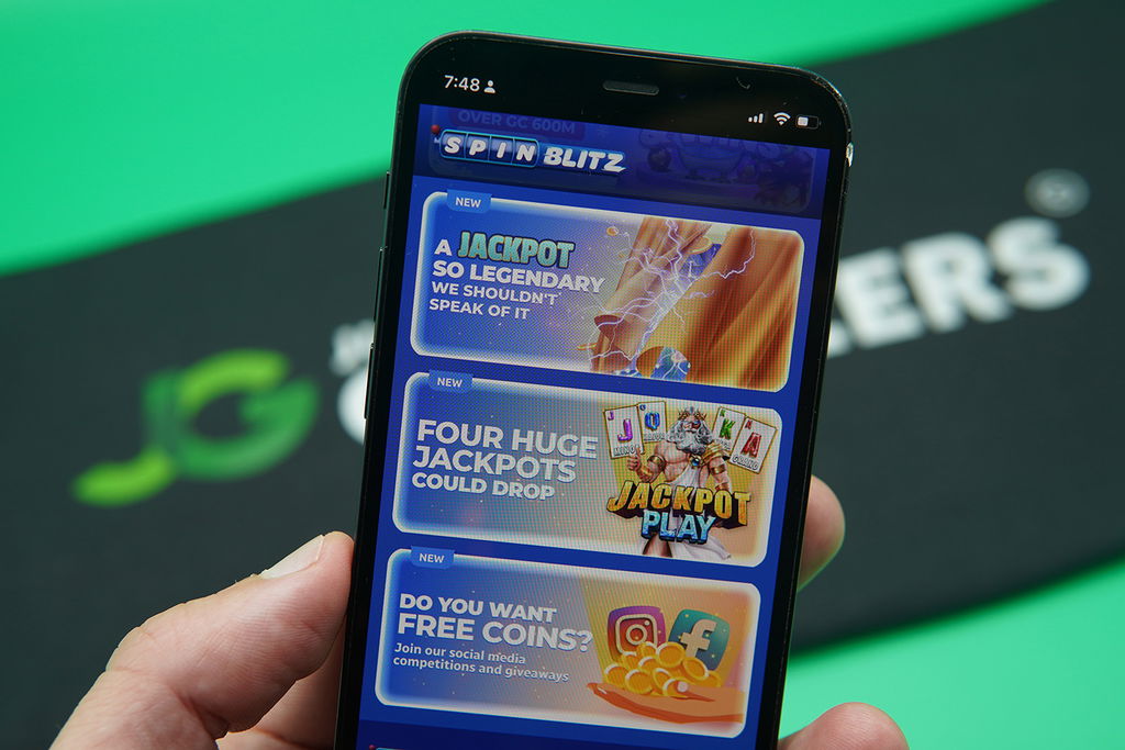 Patrik Lidin holding an iPhone with the SpinBlitz rewards page loaded on the webpage.