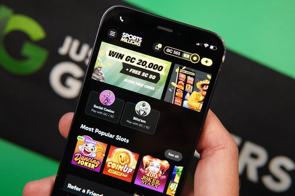 Patrik Lidin holding an iPhone with the Sports Millions sweepstakes casino landing page loaded on the webpage.