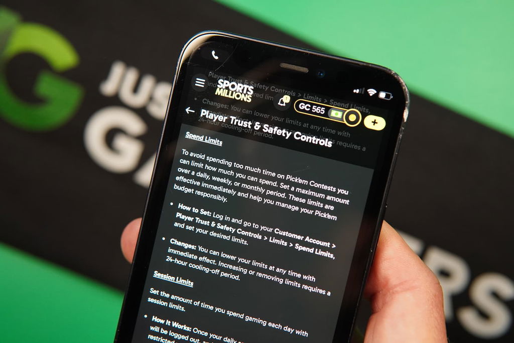 Patrik Lidin holding an iPhone with the Sports Millions sweepstakes casino responsible gaming page loaded on the webpage.