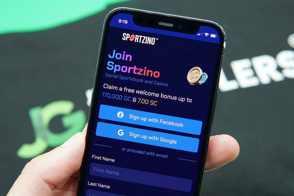 Patrik Lidin holding an iPhone with the Sportzino casino registration page loaded on the webpage.