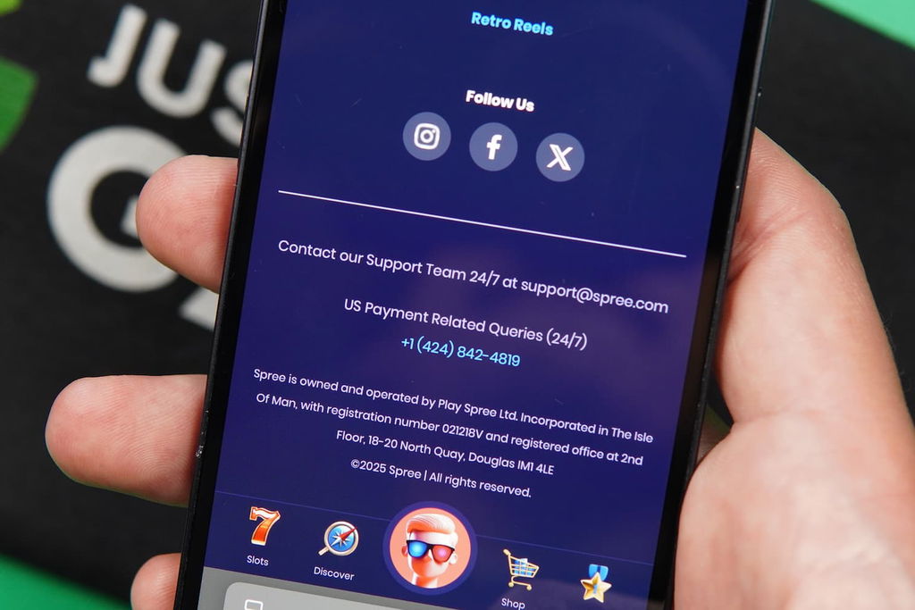 Patrik Lidin holding an iPhone with the Spree casino support page loaded on the webpage.