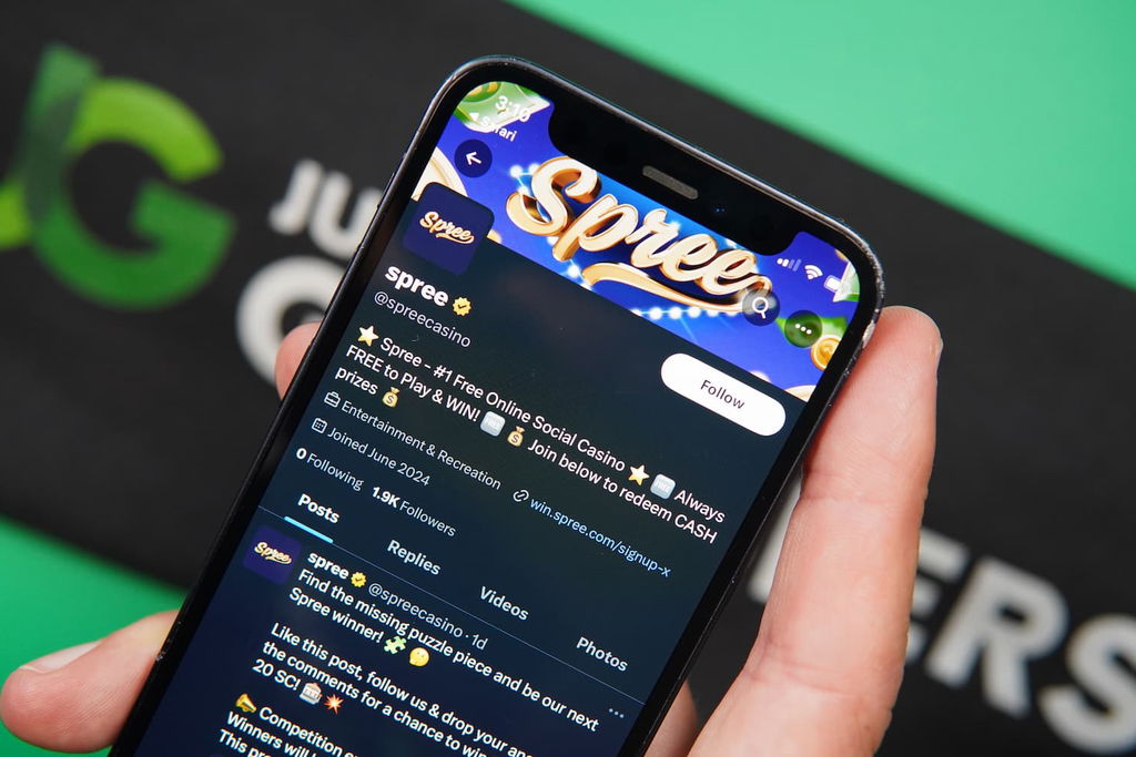 Patrik Lidin holding an iPhone with the Spree casino trust X page loaded on the webpage.