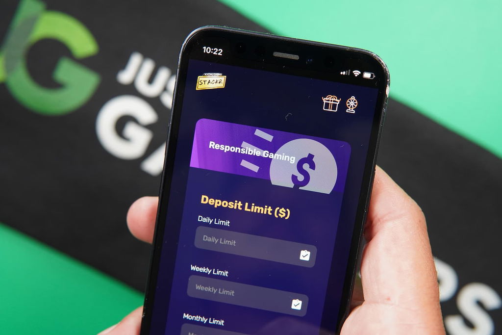 Patrik Lidin holding an iPhone with the Stackr casino Responsible Gaming page loaded on the webpage.