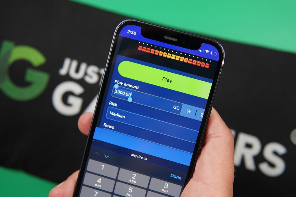 Photo of Patrik Lidin holding an iPhone showing the stake option in Plinko.