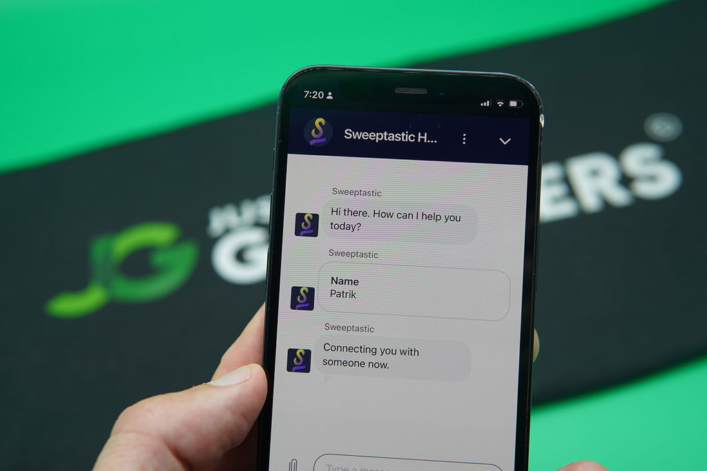 Patrik Lidin holding an iPhone while using the Sweeptastic customer support.