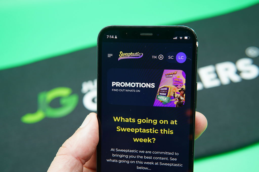 Patrik Lidin holding an iPhone with the Sweeptastic rewards page loaded on the webpage.