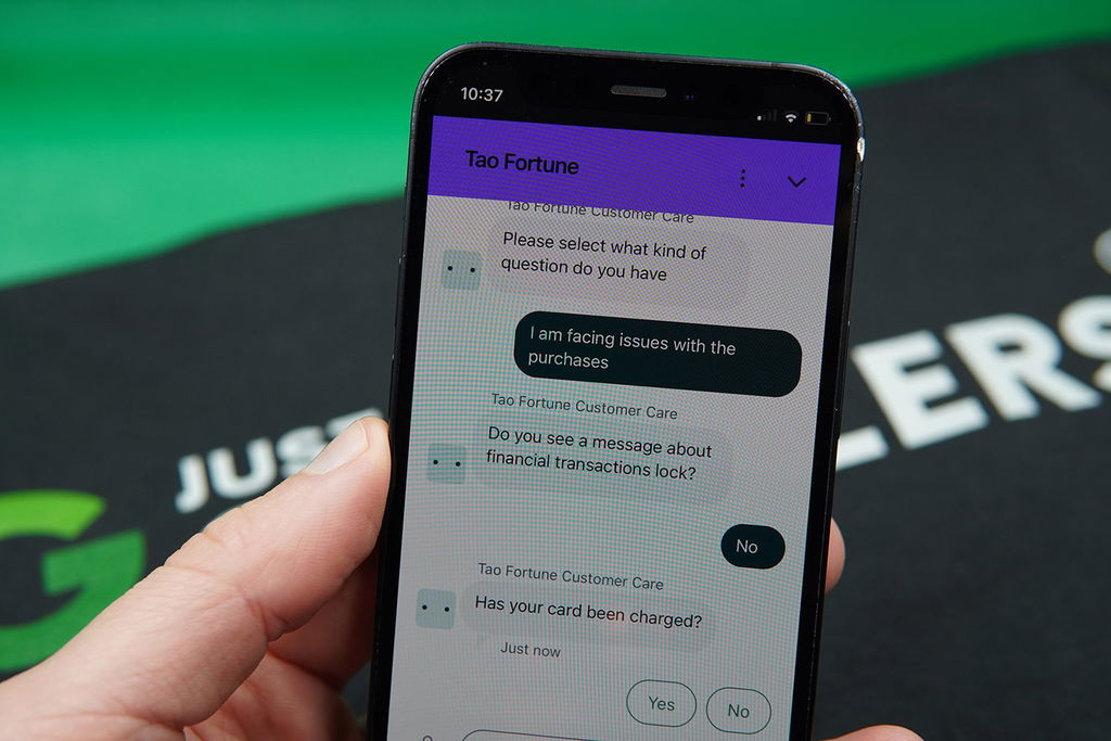 Patrik Lidin holding an iPhone while using the TaoFortune customer support.