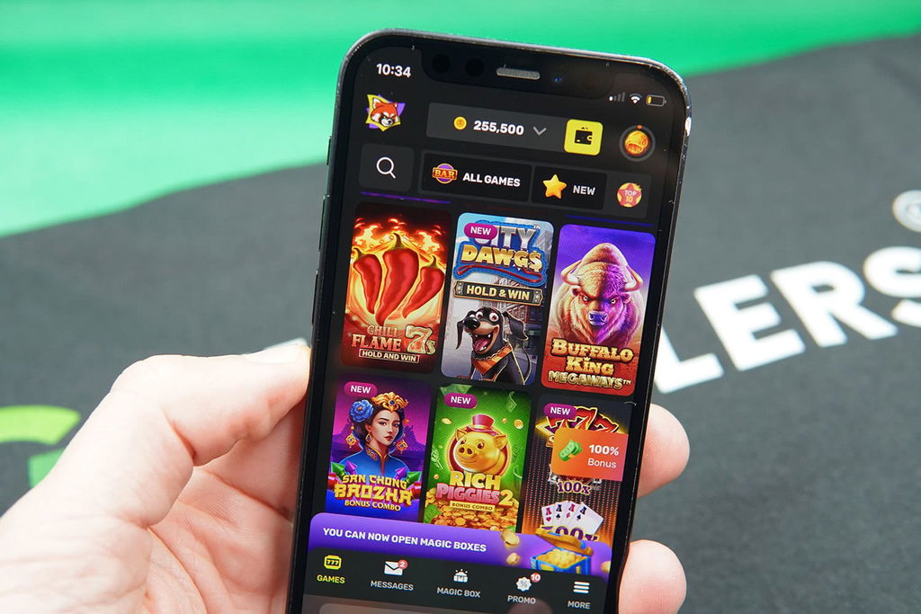 Patrik Lidin holding an iPhone with TaoFortune game library showing.