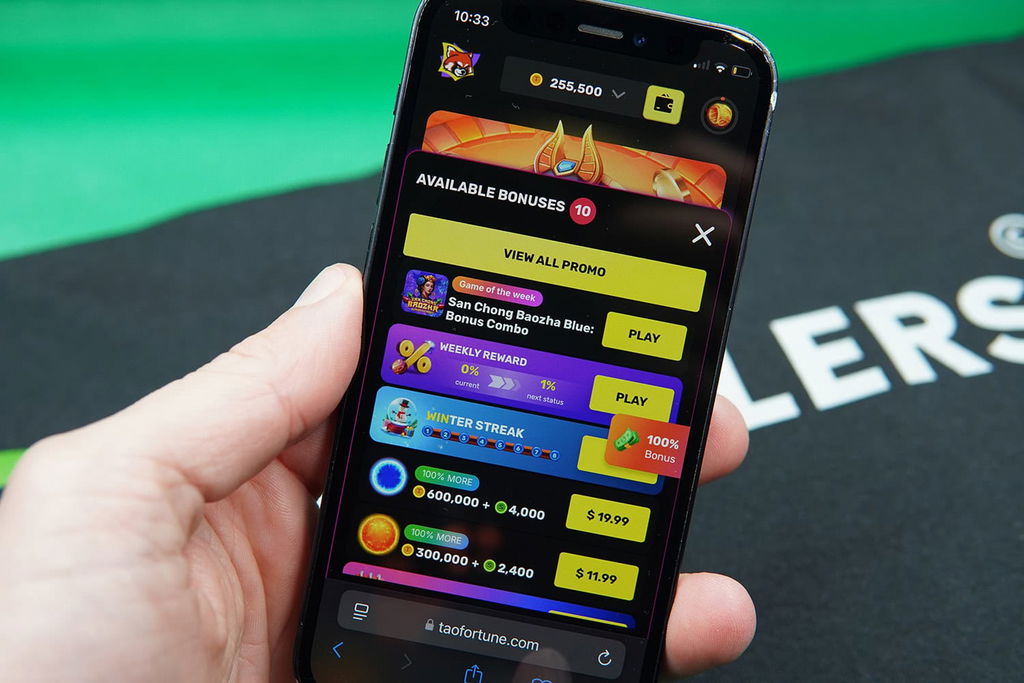 Patrik Lidin holding an iPhone with the TaoFortune rewards page loaded on the webpage.