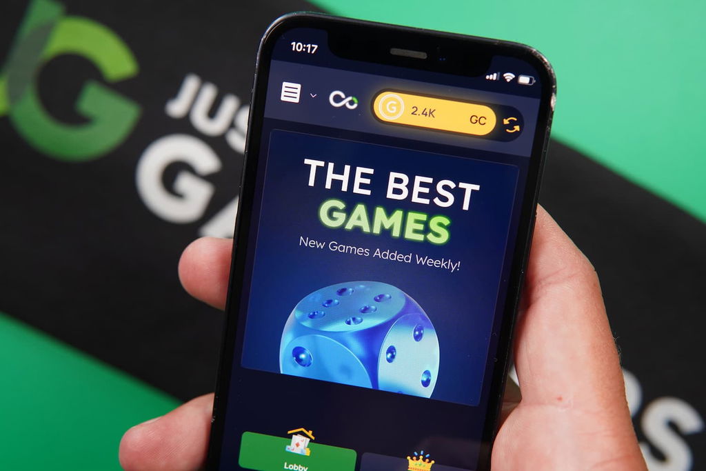 Patrik Lidin holding an iPhone with the Vegas Coins casino landing page loaded on the webpage.