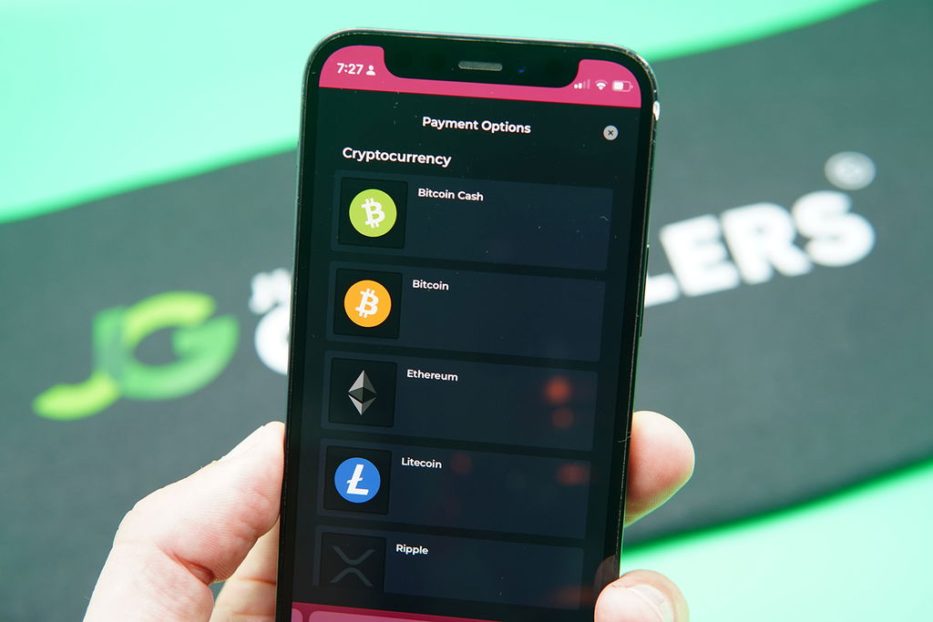 Patrik Lidin holding an iPhone when showing cryptocurrencies options at Vegas Gems.