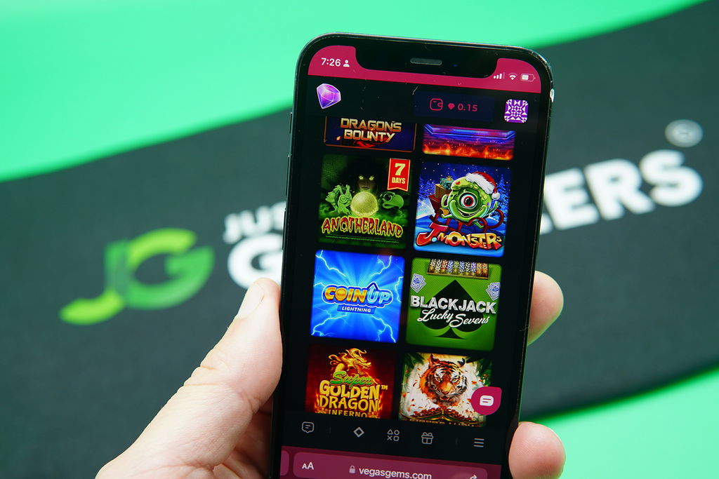 Patrik Lidin holding an iPhone with Vegas Gems game library showing.