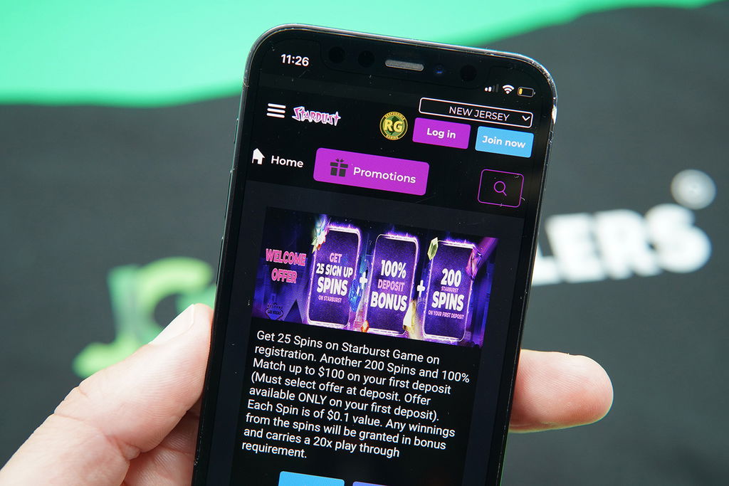 Photo of Patrik Lidin holding the Stardust NJ showing the details of a no deposit casino bonus.